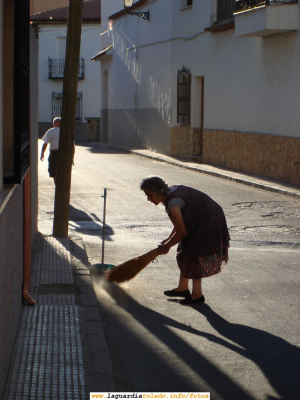 Barriendo a primera hora de la mañana en la Calle Levante "la María"
Es tradición en los pueblos que el espacio común de la calle sea barrido y adecentado por las personas que viven en la zona concreta de la calle contigua a la casa. La denominación de calle Levante está clara, por su orientación. El sol nace por Levante (Este). De ahí que los rayos de sol entren con esa orientación a primera hora de la mañana.
