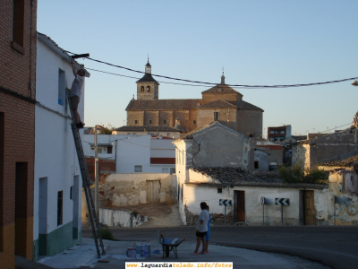 Vista de la Iglesia Parroquial desde la calle Arrabal, a la altura de la peligrosa curva de la antigua carretera de Andalucía. Agosto de 2006
Como puede verse, aparecen en la instantánea dando cal ("enjabelgando" como dicen aquí) como es típico en estas fechas

