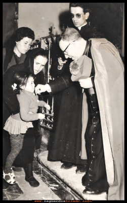 BESANDO EL ANILLO
Carmen Espada Huete con  6 años besa el anillo del obispo, ayudada por la tía Aurelia “la malaña”, por detrás esta Paca Pedraza. y al lado del obispo, don José Vicente González.  Año 1965
Keywords:  besa  anillo obispo